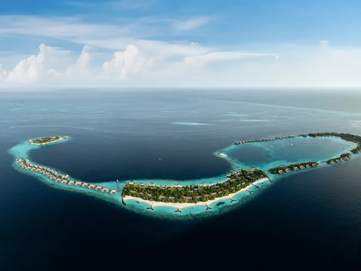 Aerial view of Waldorf Astoria Maldives Ithaafushi with overwater villas and turquoise lagoon