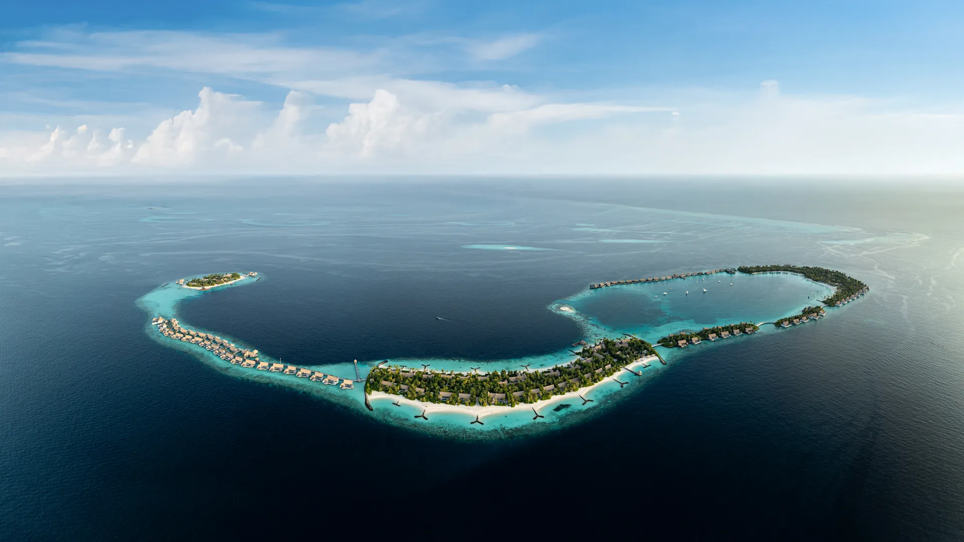 Aerial view of Waldorf Astoria Maldives Ithaafushi with overwater villas and turquoise lagoon