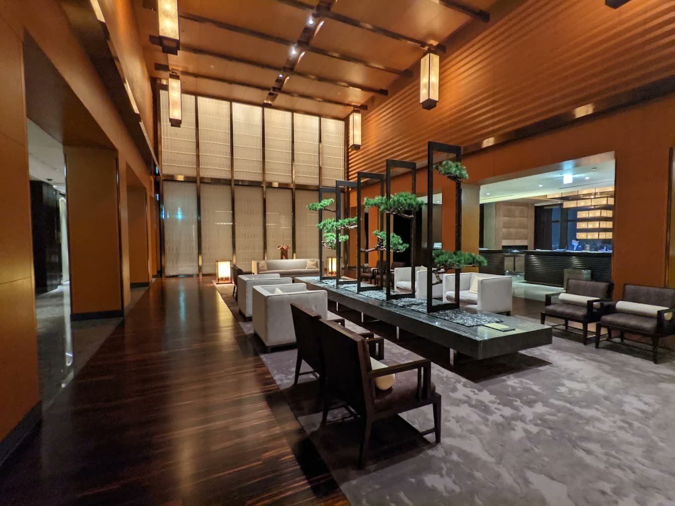 Double-height lounge with timber screens, lanterns and bonsai