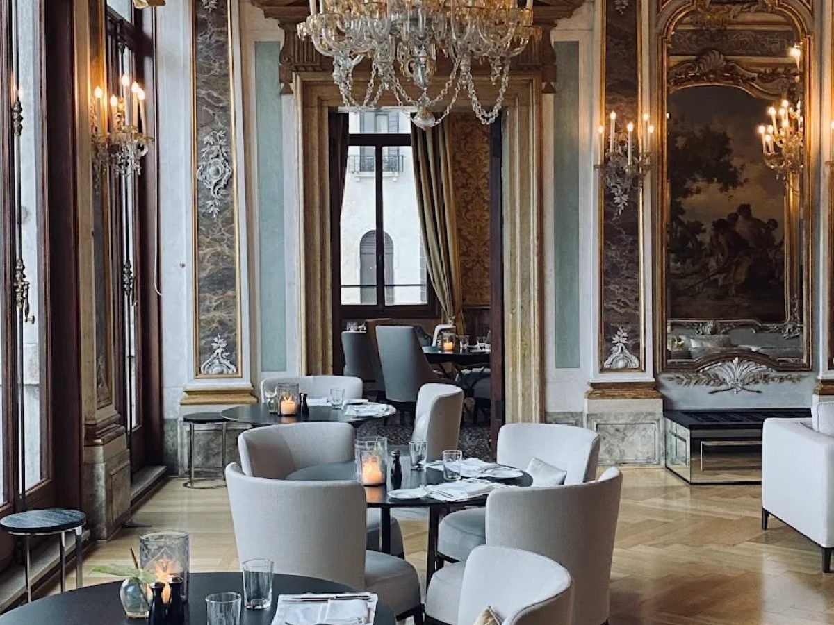 High-ceilinged dining room with a crystal chandelier and gilded panelling