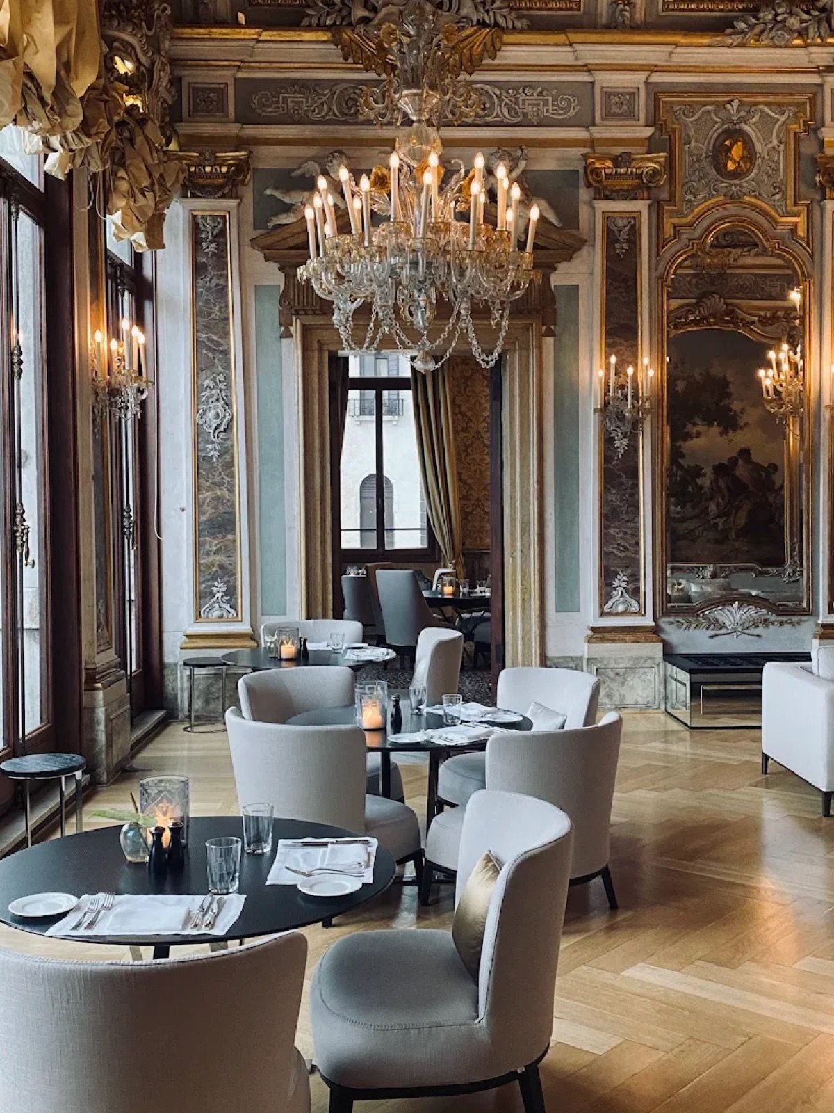 High-ceilinged dining room with a crystal chandelier and gilded panelling