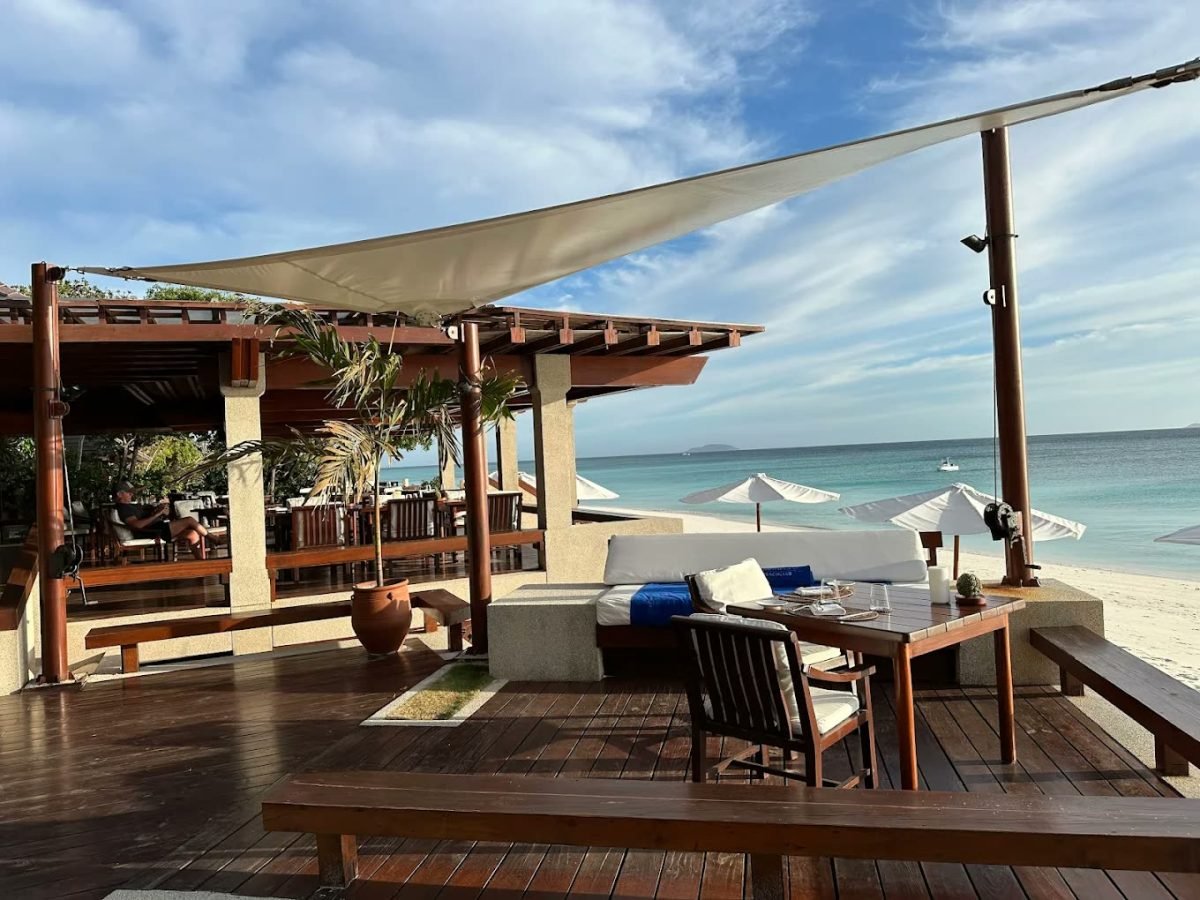 Sail-shaded deck of the beach club above white sand at Amanpulo, Palawan