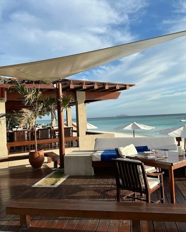Sail-shaded deck of the beach club above white sand at Amanpulo, Palawan