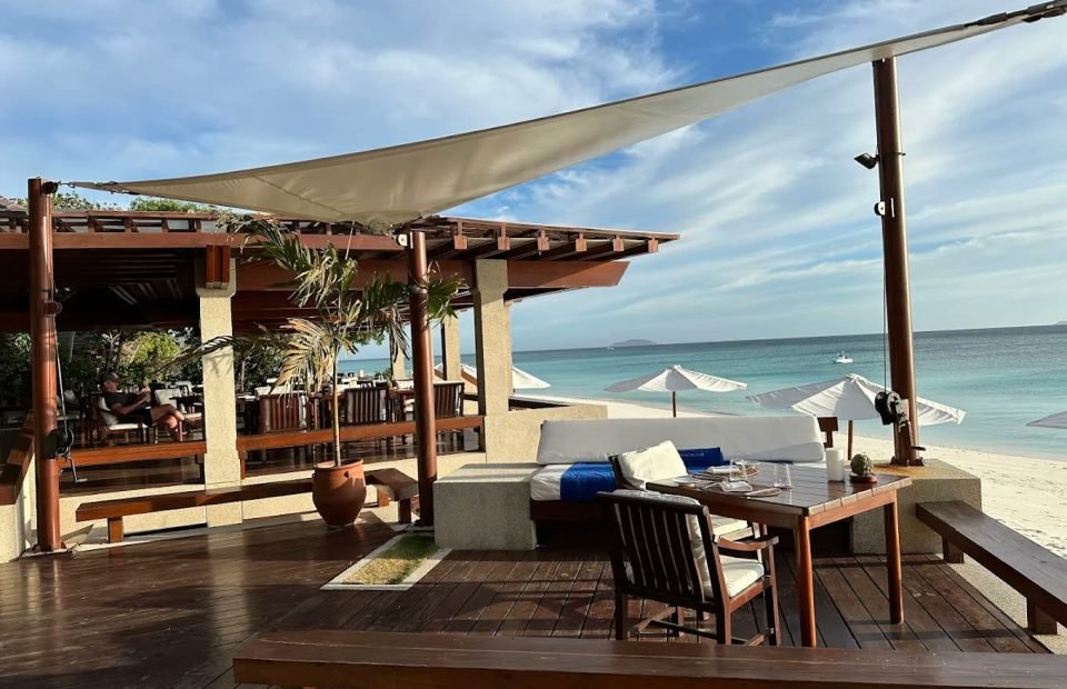 Sail-shaded deck of the beach club above white sand at Amanpulo, Palawan