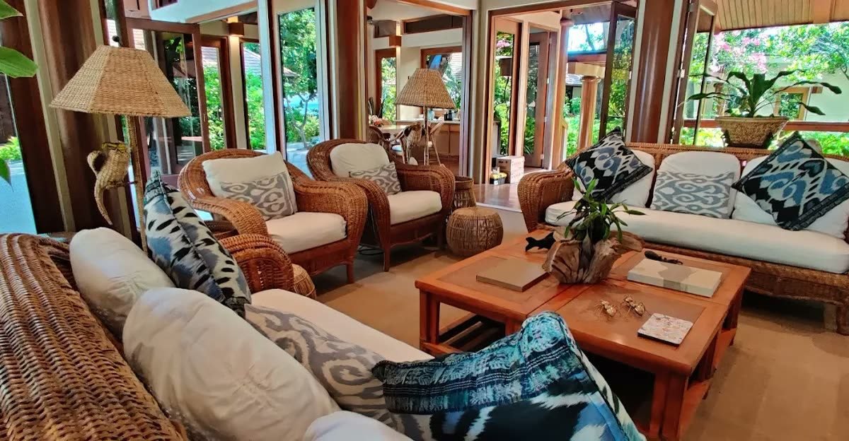 Rattan lounge pavilion with ikat cushions opening to tropical gardens