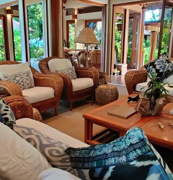 Rattan lounge pavilion with ikat cushions opening to tropical gardens