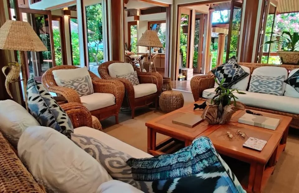 Rattan lounge pavilion with ikat cushions opening to tropical gardens