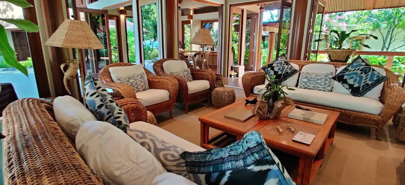 Rattan lounge pavilion with ikat cushions opening to tropical gardens