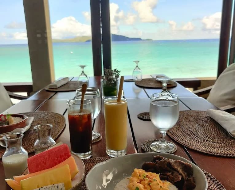 Breakfast laid on a shaded veranda with a sea view