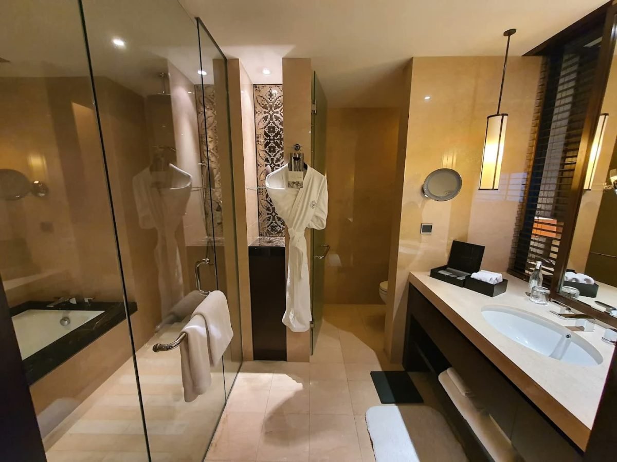 Marble suite bathroom with soaking tub and bathrobe at Fairmont Jakarta