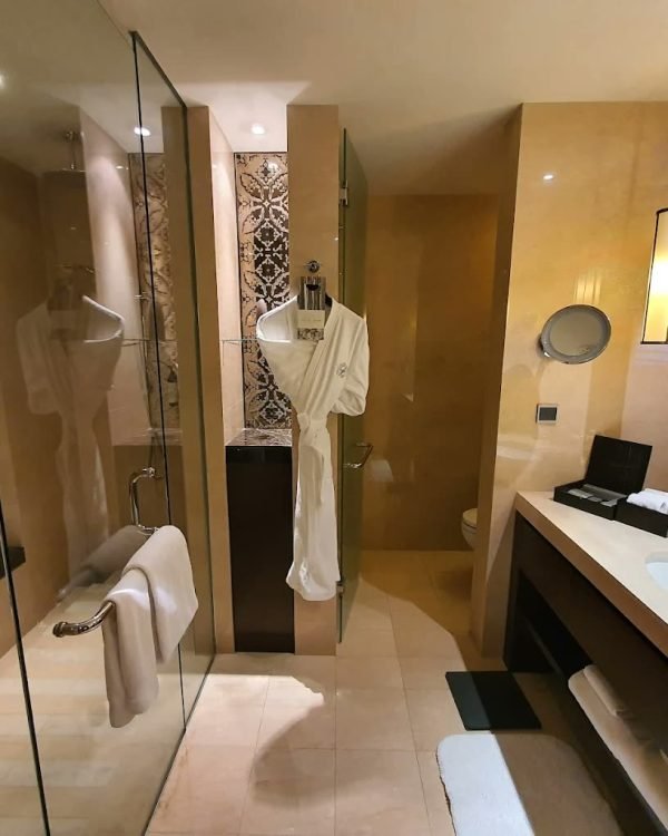 Marble suite bathroom with soaking tub and bathrobe at Fairmont Jakarta