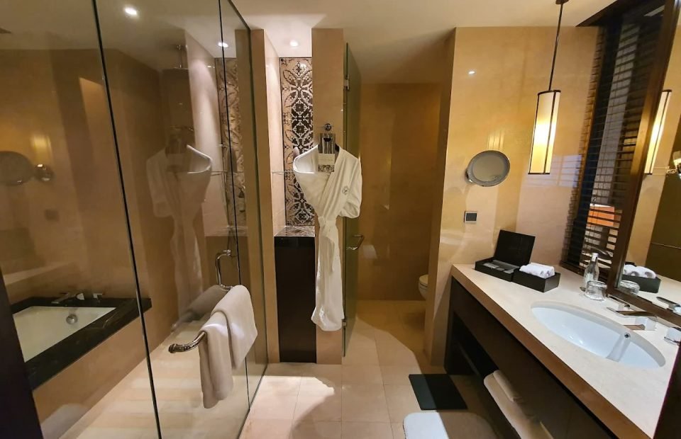 Marble suite bathroom with soaking tub and bathrobe at Fairmont Jakarta