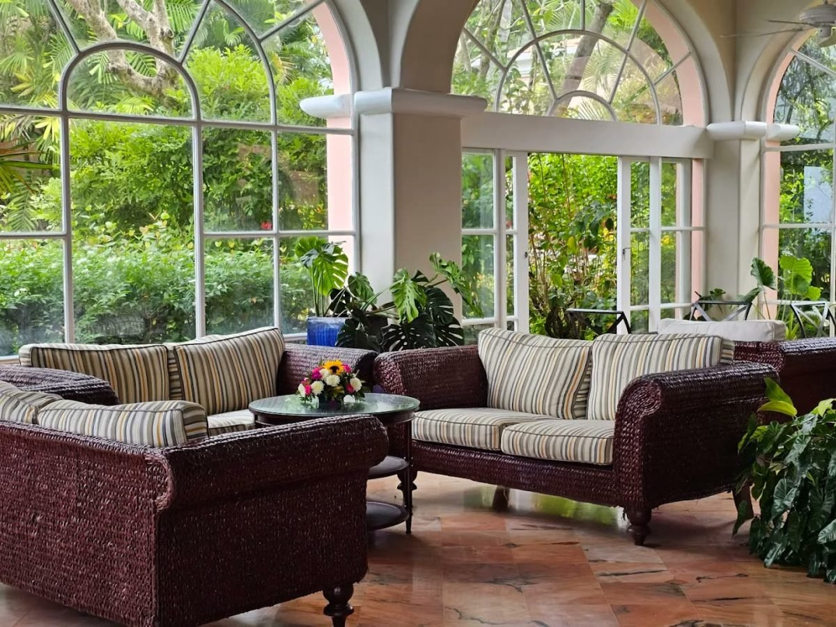 Wicker sofas in the plant-filled garden lounge at Fairmont Royal Pavilion