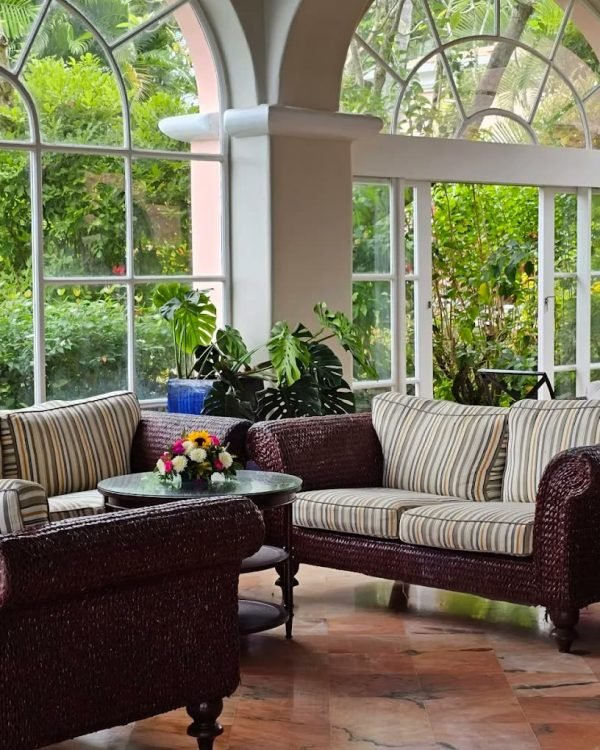Wicker sofas in the plant-filled garden lounge at Fairmont Royal Pavilion