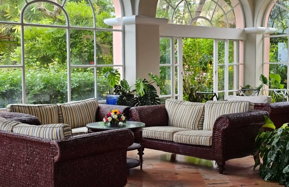 Wicker sofas in the plant-filled garden lounge at Fairmont Royal Pavilion