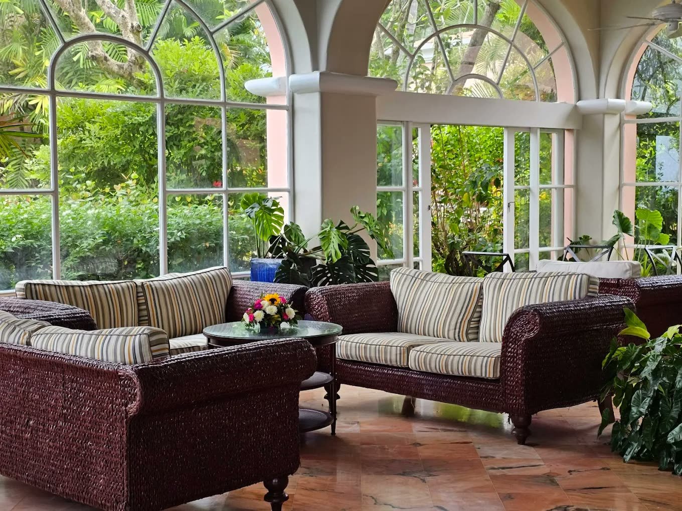 Wicker sofas in the plant-filled garden lounge at Fairmont Royal Pavilion