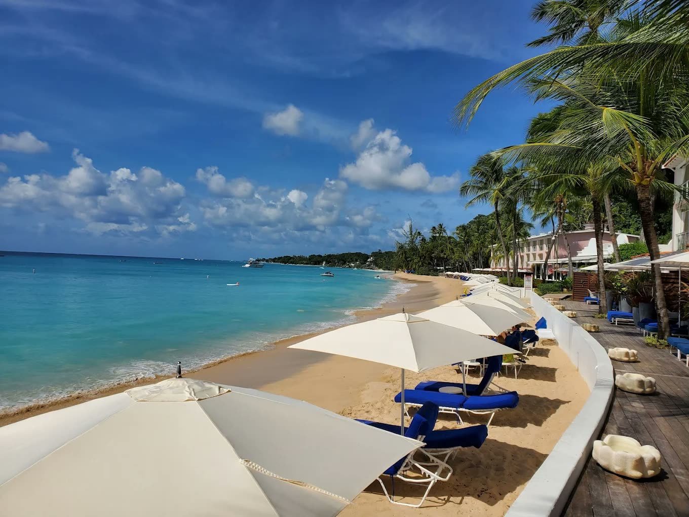 White parasols and loungers on the beach at Fairmont Royal Pavilion, Barbados