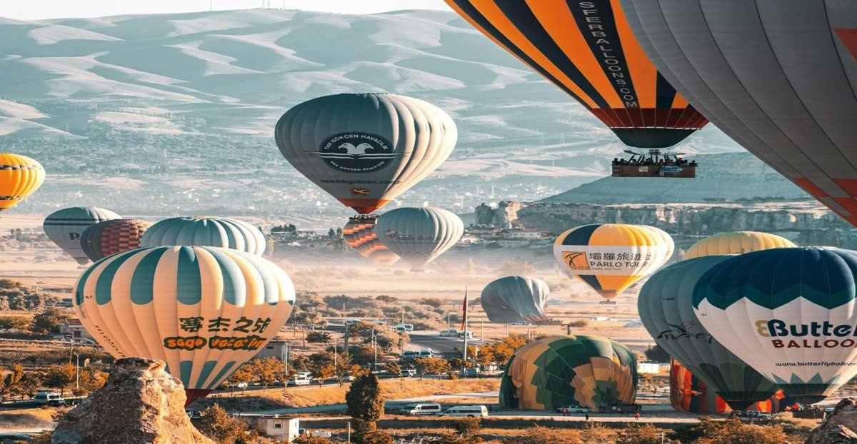 Dozens of hot air balloons lifting off over Goreme, Cappadocia