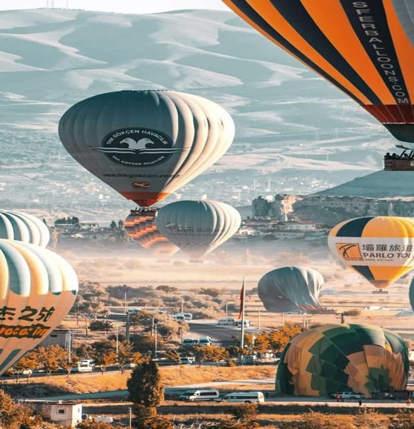 Dozens of hot air balloons lifting off over Goreme, Cappadocia