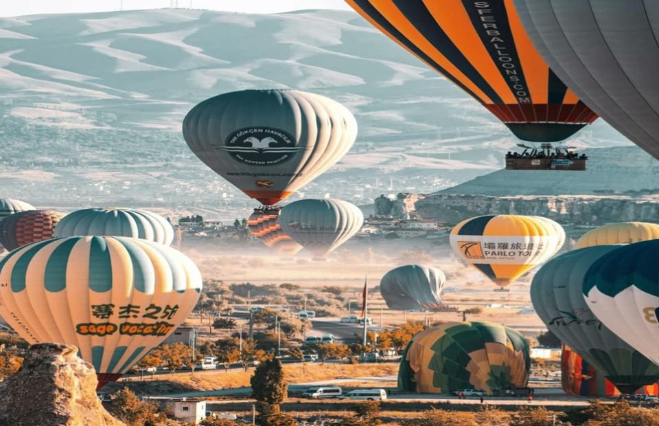 Dozens of hot air balloons lifting off over Goreme, Cappadocia