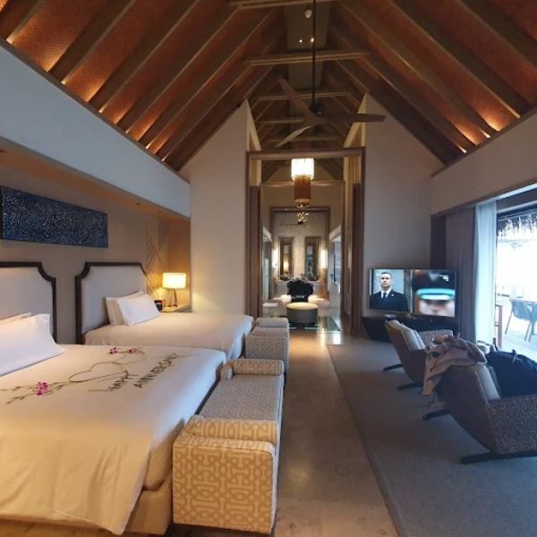 Vaulted timber ceiling and twin beds inside a Maldives overwater villa