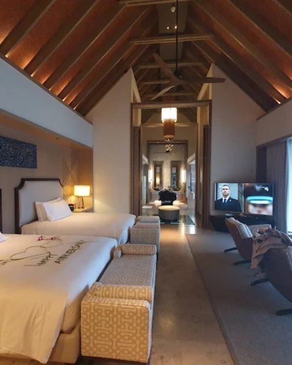 Vaulted timber ceiling and twin beds inside a Maldives overwater villa