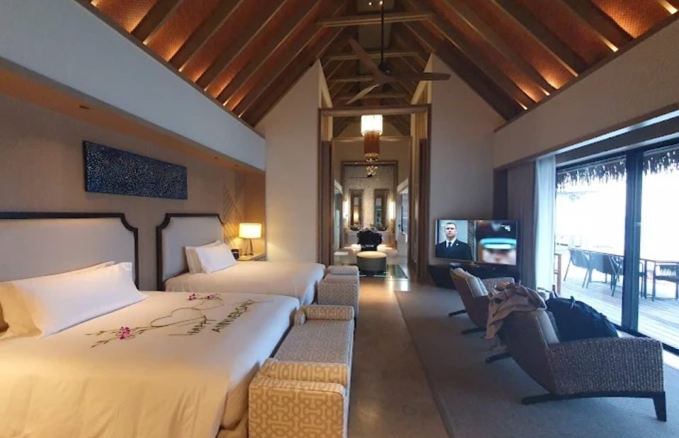Vaulted timber ceiling and twin beds inside a Maldives overwater villa