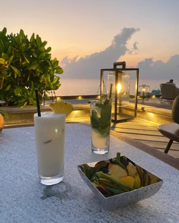 Cocktails on a resort deck at sunset in the Maldives
