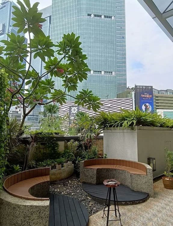 Planted terrace seating beneath the towers at Mandarin Oriental Jakarta