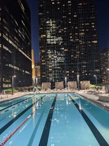 Outdoor lap pool beneath the Chicago skyline at night at Radisson Blu Aqua Hotel