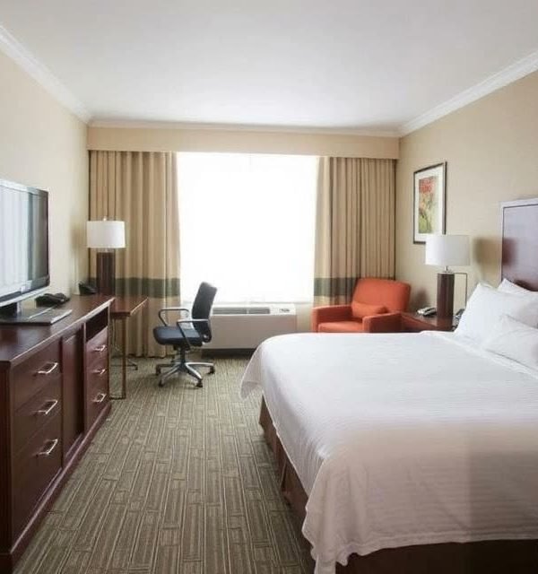 Guest room with armchair and city window at Radisson Hotel Cedar Rapids