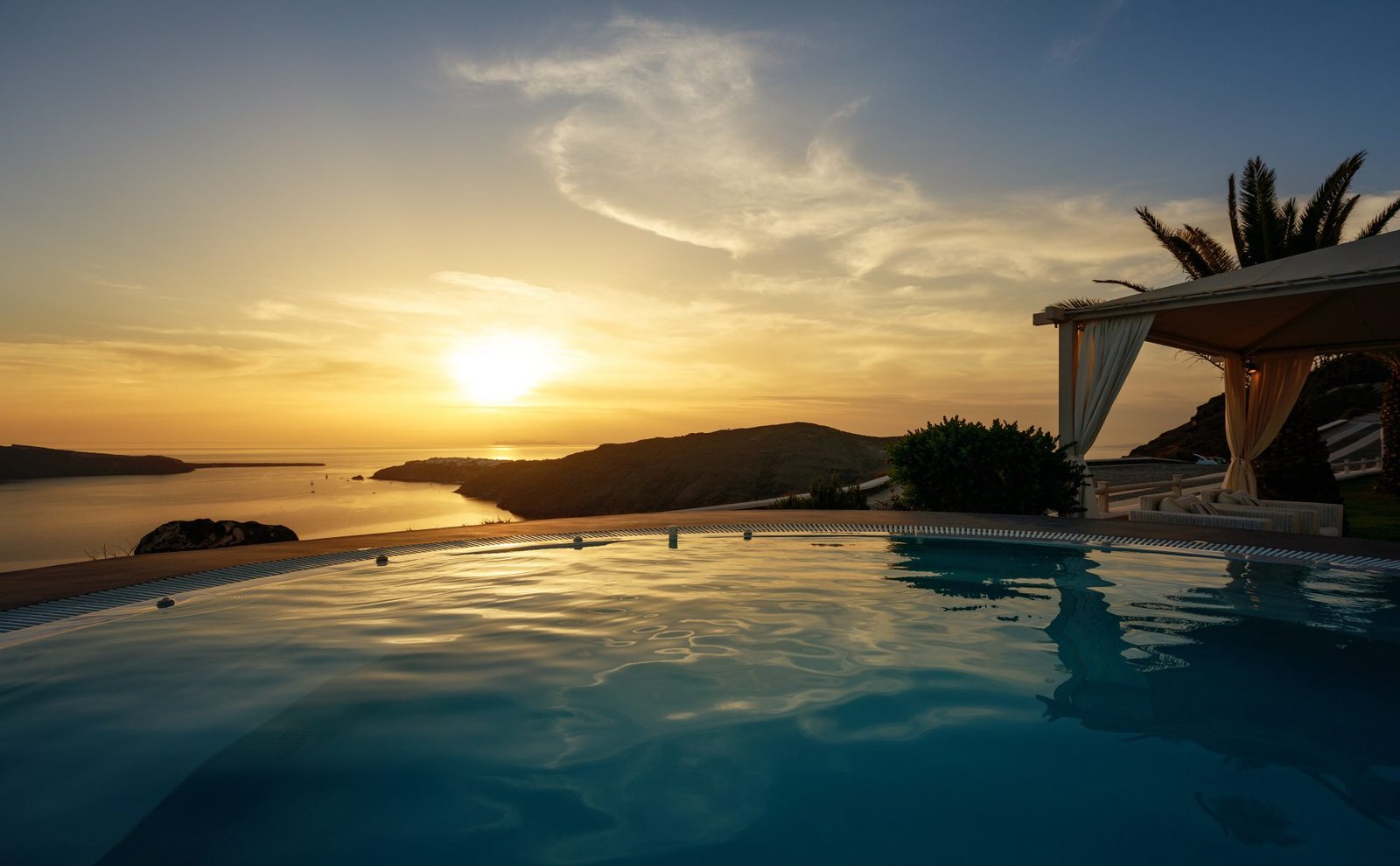 Cliffside infinity pool overlooking the sea at dusk