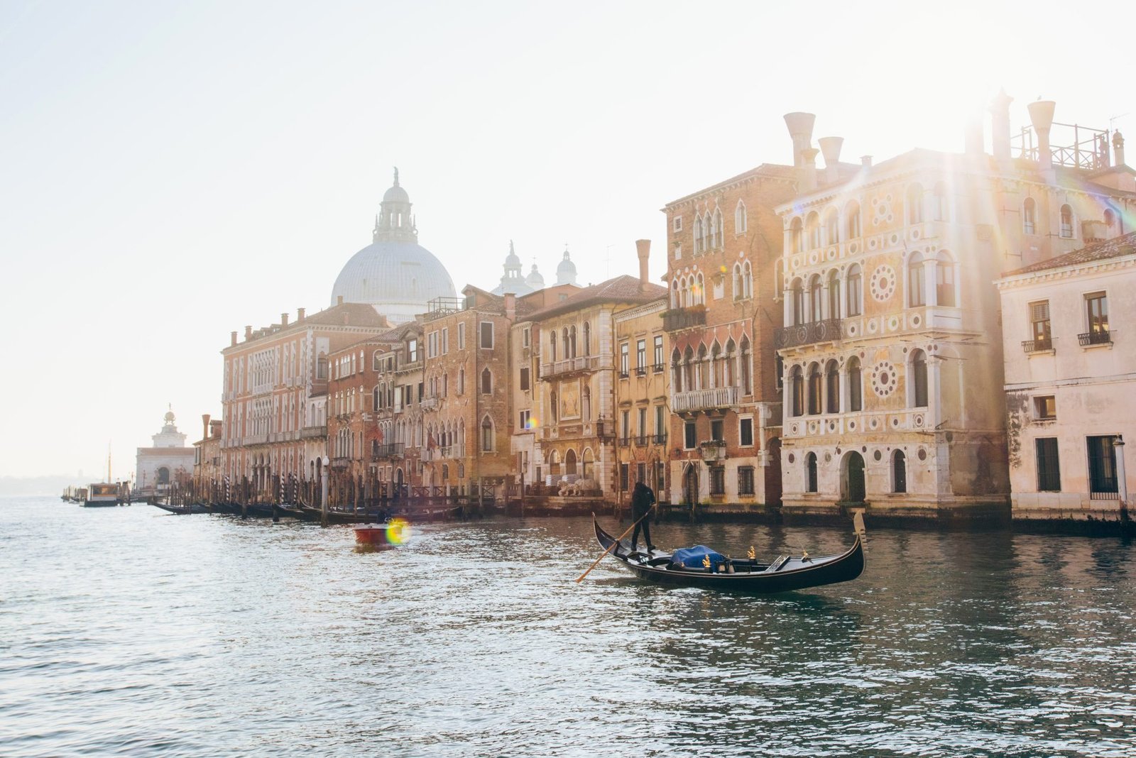Grand Canal in Venice with a gondola and the Salute dome at sunrise