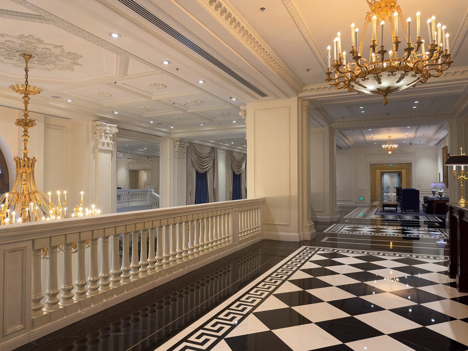 Classic grand hotel corridor with ornate chandeliers and marble floor
