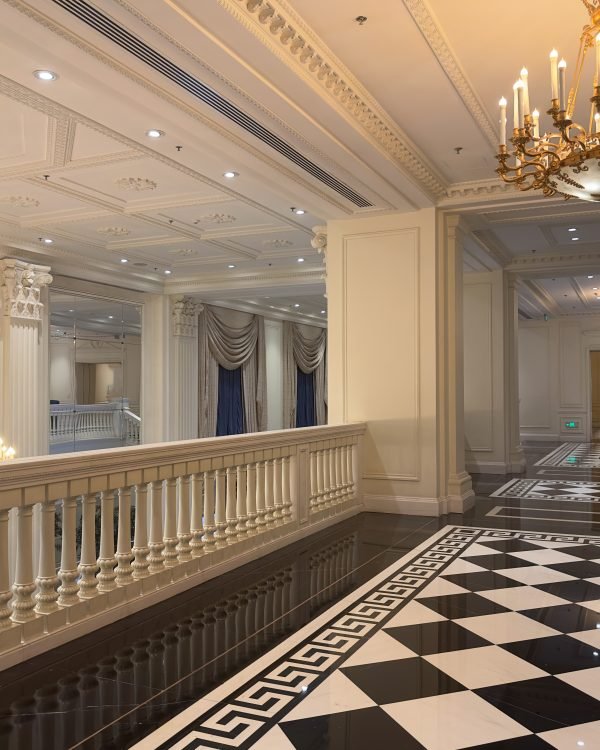Classic grand hotel corridor with ornate chandeliers and marble floor