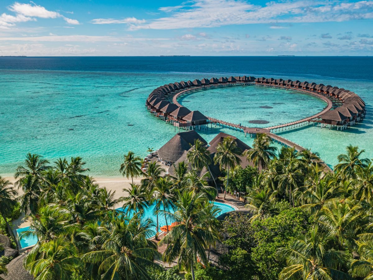 Aerial view of Maldives overwater villas and palm island