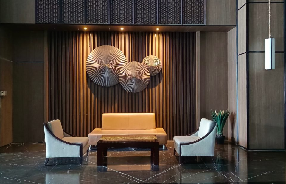 Dark hotel lounge with a gold slatted wall and brass discs