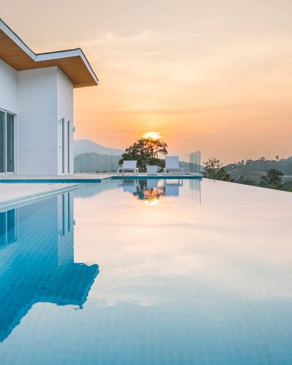 Modern villa mirrored in a still infinity pool at sunset