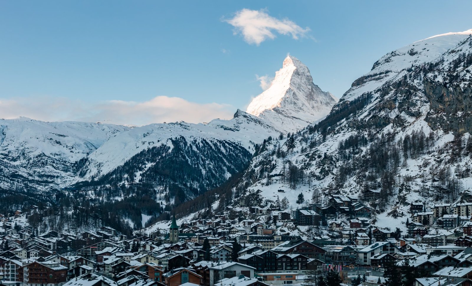 The Matterhorn rising above snow-covered Zermatt rooftops