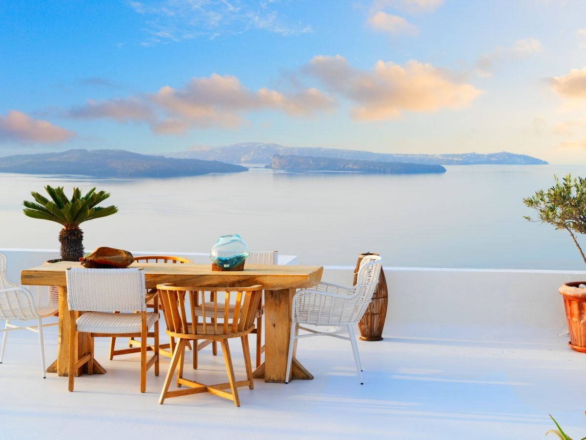 Dining table on a white Santorini caldera terrace at sunset