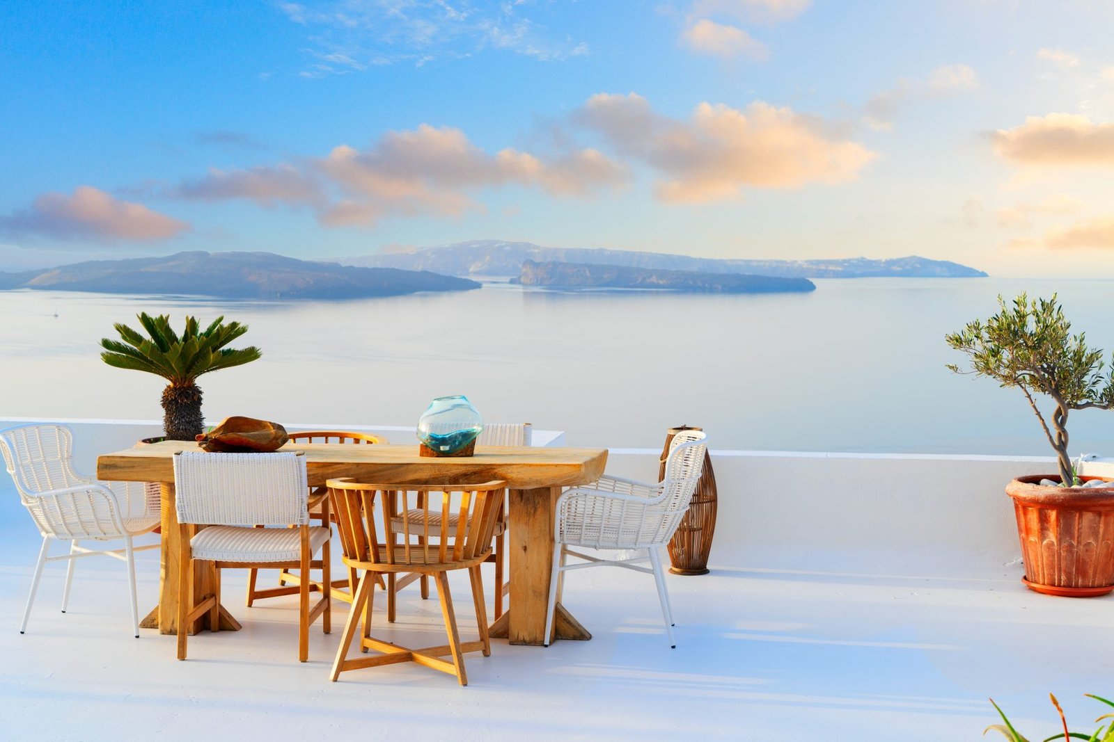 Dining table on a white Santorini caldera terrace at sunset
