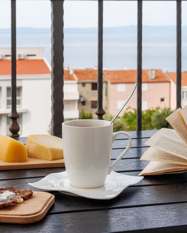 Coffee and a book on a balcony over terracotta rooftops