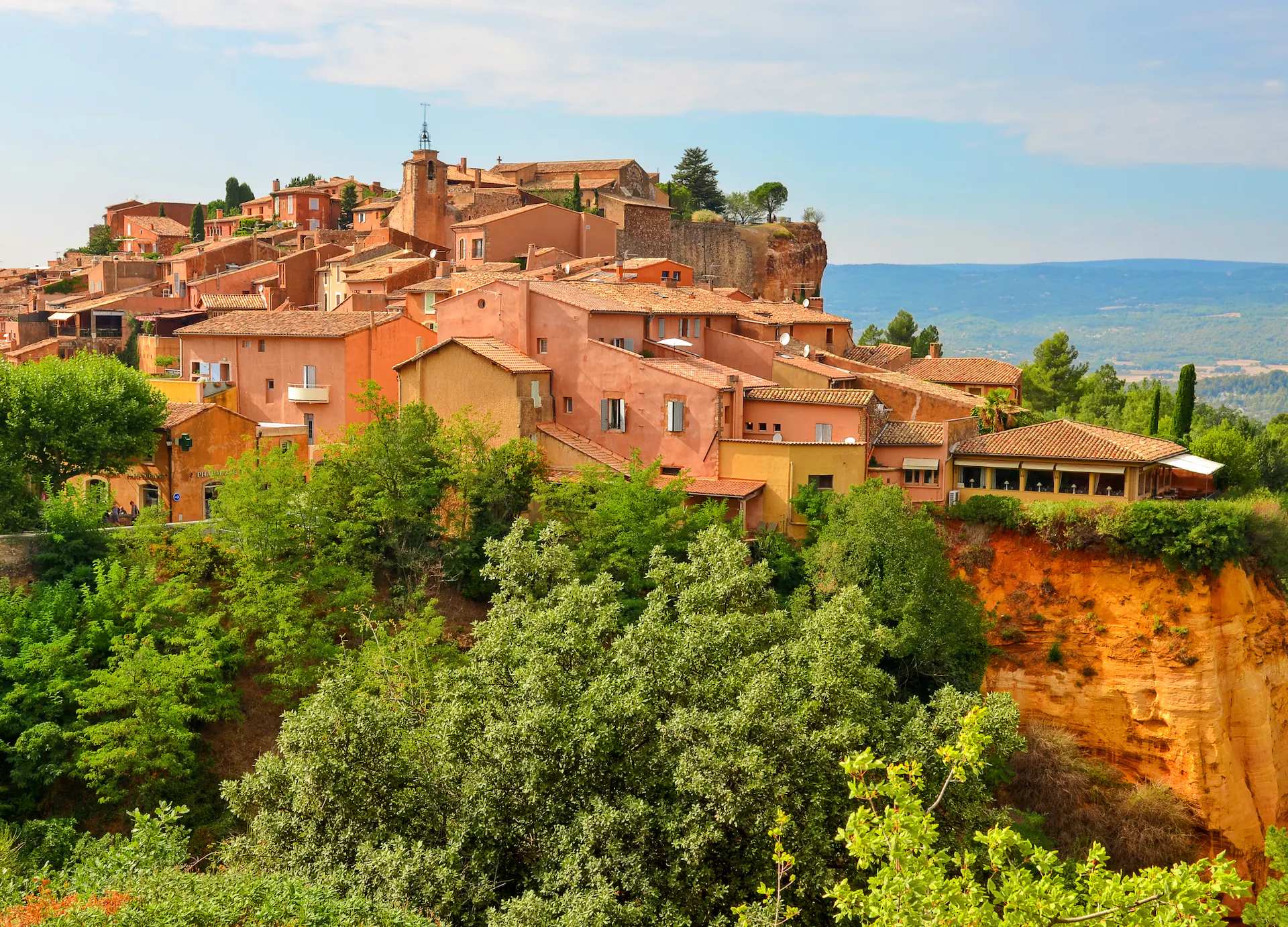 Panoramic view of Roussillon village in Provence, France, with colourful ochre buildings and dramatic cliffs
