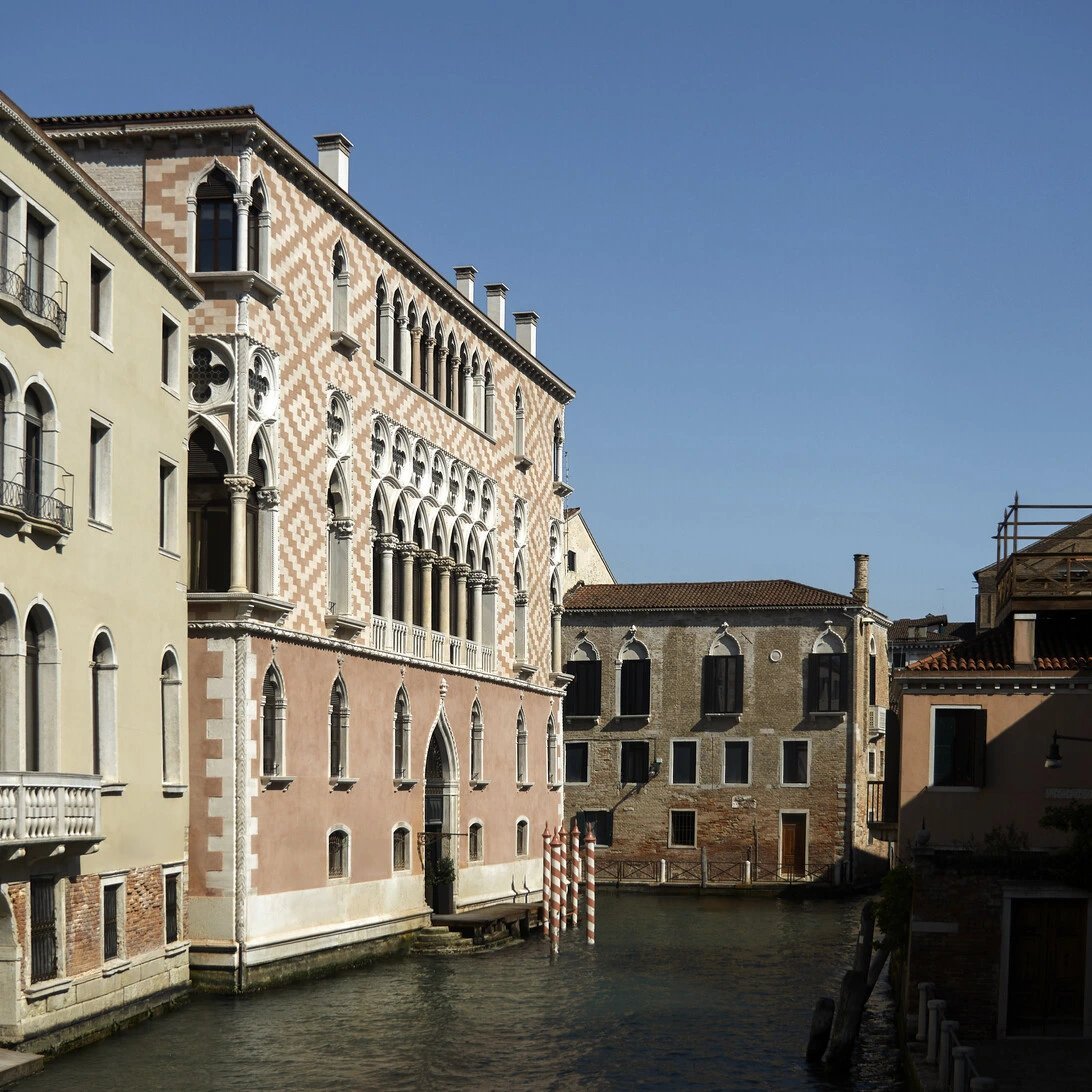 Gothic façade of Palazzo Donà Giovannelli with a row of pointed windows above a canal in Cannaregio, Venice