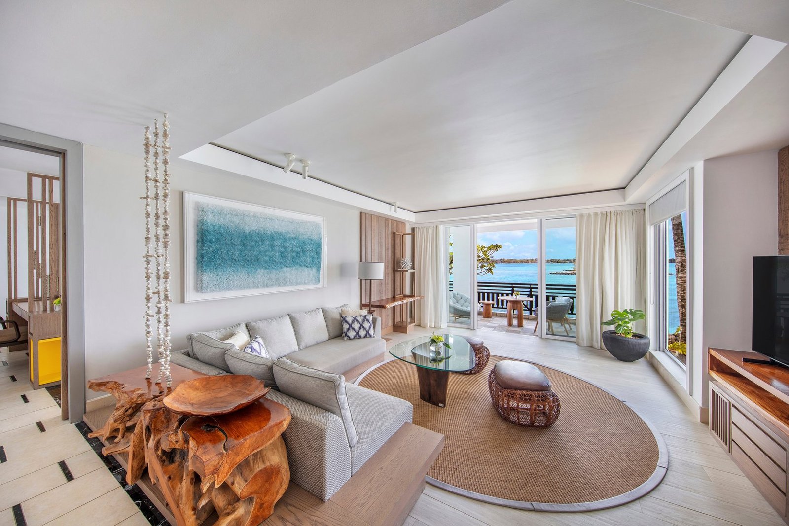 Redesigned guest room at Shangri-La Le Touessrok with rattan furniture, botanical prints and a terrace facing the Indian Ocean