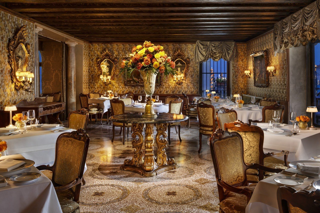 Club del Doge Restaurant at The Gritti Palace with formally set tables beside windows onto the Grand Canal