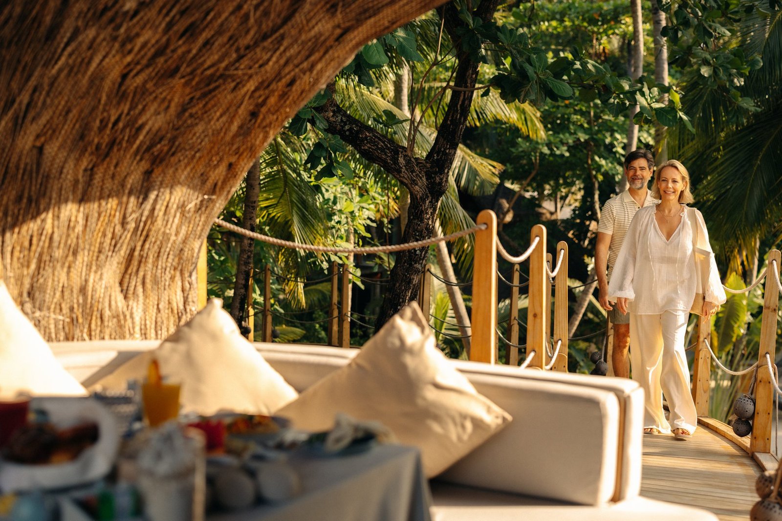 Sandy pathway lined with tropical palms and greenery on Muravandhoo Island at JOALI Maldives