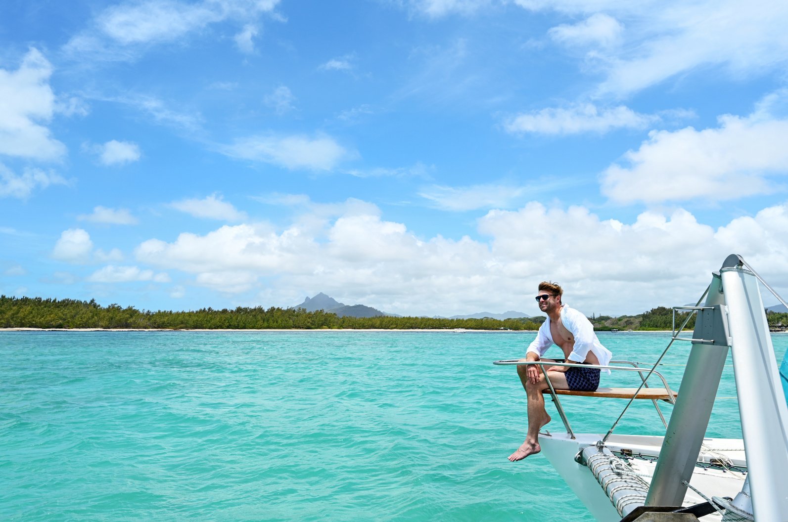 Small boat crossing the turquoise lagoon at Trou d'Eau Douce toward Ilot Mangénie, Mauritius